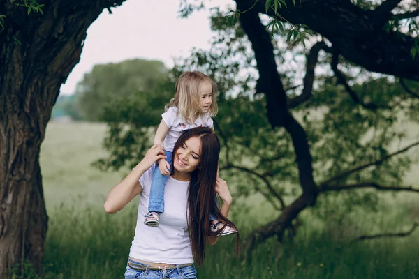 Criança perto da árvore com a mãe — Fotografia de Stock
