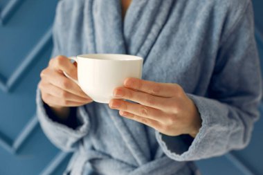 Mavi bornozla stüdyoda duran güzel kız.