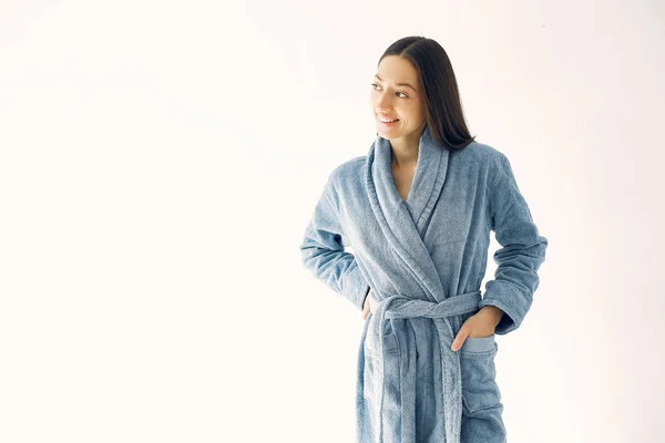 Beautiful girl standing in a studio in a blue bathrobe — Stock Photo, Image