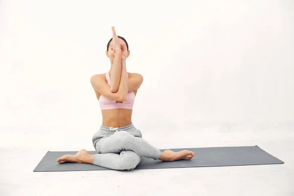 Una bella ragazza è impegnata in uno studio di yoga — Foto Stock