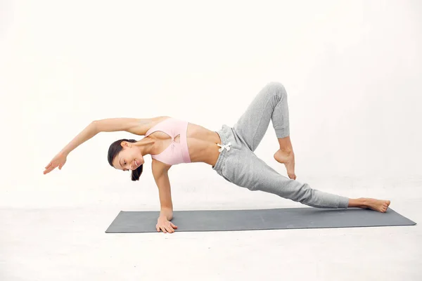 Una bella ragazza è impegnata in uno studio di yoga — Foto Stock