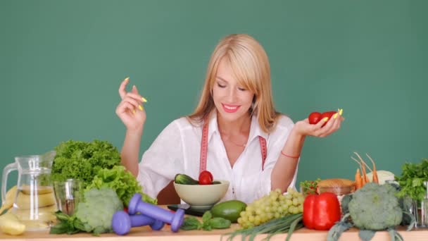 Adatta donna che misura vegetariani su scaglie a un tavolo su sfondo verde — Video Stock