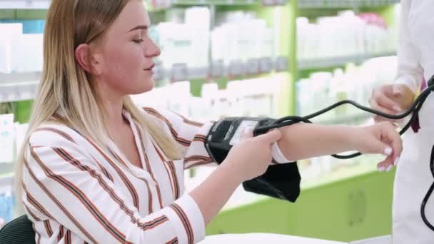 Farmasøyt som kontrollerer kundens blodtrykk – stockvideo