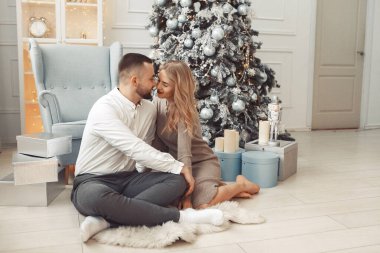 Noel ağacının yanında oturan zarif bir çift.