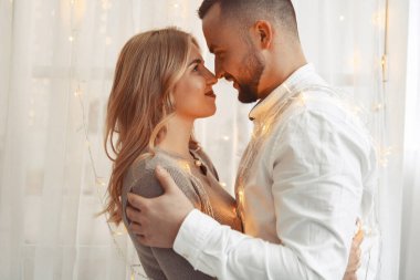 Bir odada garlangla duran zarif bir çift.