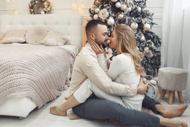 Noel ağacının yanında oturan zarif bir çift.