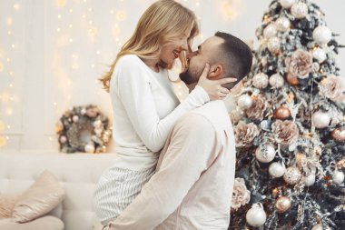 Noel ağacının yanında duran zarif çift.