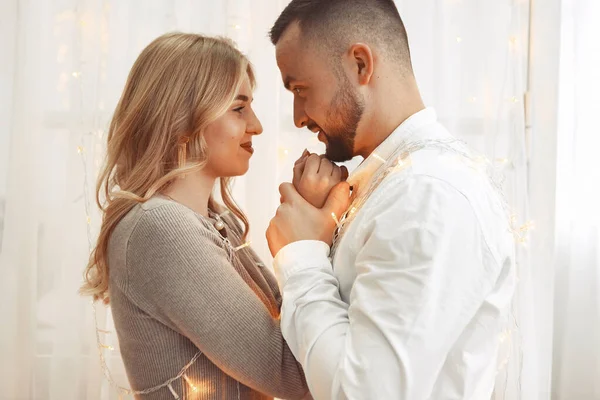 Elegant couple standing with a garlang in a room — Stock Photo, Image