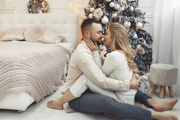 Noel ağacının yanında oturan zarif bir çift.