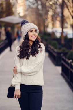 Şehirde beyaz kazak giyen tatlı bir esmer.