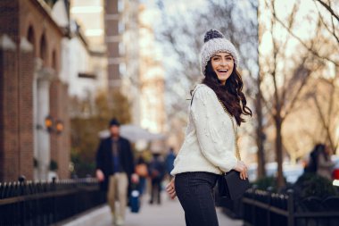 Şehirde beyaz kazak giyen tatlı bir esmer.
