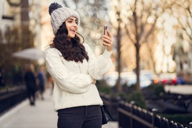 Şehirde beyaz kazak giyen tatlı bir esmer.
