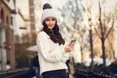 Şehirde beyaz kazak giyen tatlı bir esmer.