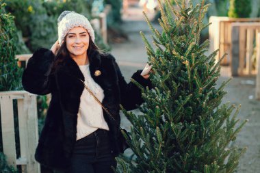 Beyaz süveter ve Noel ağacı içinde tatlı bir esmer.