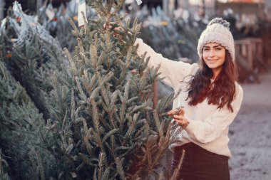 Beyaz süveter ve Noel ağacı içinde tatlı bir esmer.