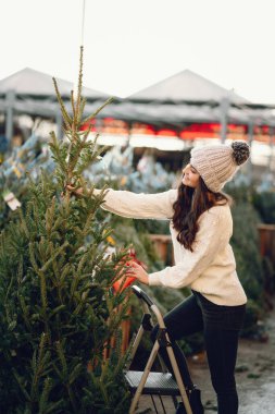 Beyaz süveter ve Noel ağacı içinde tatlı bir esmer.