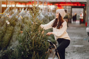 Beyaz süveter ve Noel ağacı içinde tatlı bir esmer.