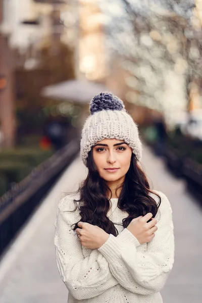 Leuke brunette in een witte trui in een stad — Stockfoto