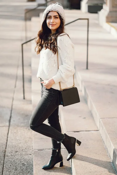 Brune mignonne dans un pull blanc dans une ville — Photo