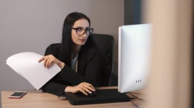 Brunetter iş kadını büroda evraklarla çalışıyor.