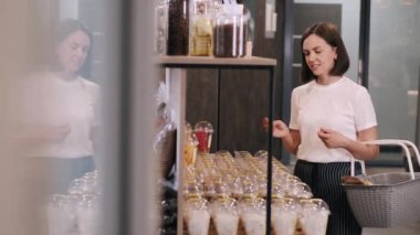 Mağazadaki kurumuş meyve raflarına bakan çekici kadın müşteri.