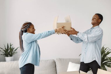 Kutuları olan çift yeni evine gülümsüyor.