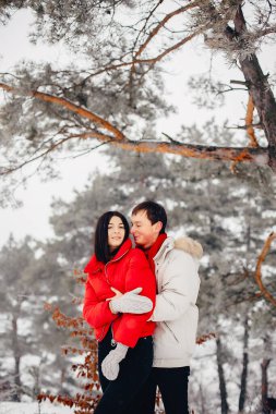 Sevgili çift kış parkında yürüyor.