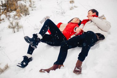 Sevgili çift kış parkında yürüyor.