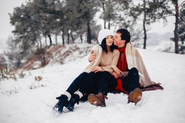 Sevgili çift kış parkında yürüyor.