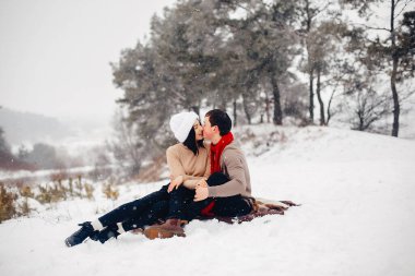 Sevgili çift kış parkında yürüyor.