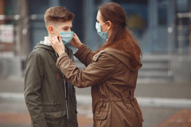 A boy and mother are wearing protective masks