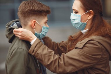A boy and mother are wearing protective masks