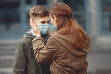 A boy and mother are wearing protective masks