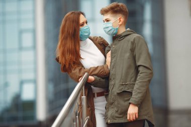 Anne ve oğlu tek kullanımlık maskeler takıyor.