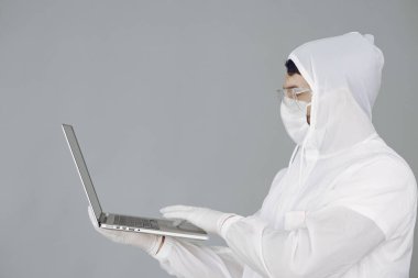 Koruyucu takım elbiseli ve gözlüklü adam stüdyoda.