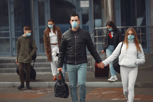 공항을 떠나는 여행자들은 보호용 마스크를 쓰고 있다 — 스톡 사진