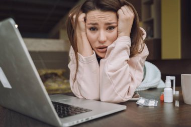 Hasta ve başı ağrıyan kadın evde oturuyor.