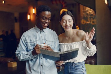 Uluslararası insanlar bir kafede durup kahve içiyorlar.