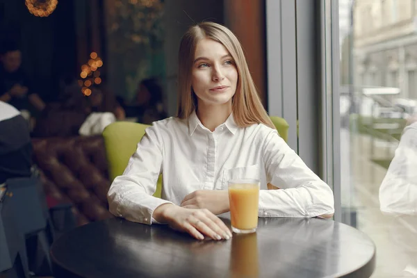 Elegáns nő fehér blúzban, sok időt tölt egy kávézóban. — Stock Fotó