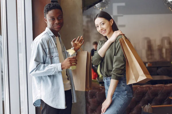 Internationale Menschen stehen mit Einkaufstüten in einem Café — Stockfoto