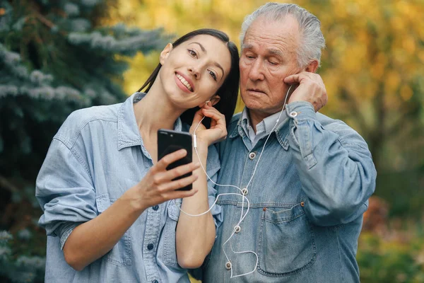 Menina ensinando seu avô como usar um telefone — Fotografia de Stock