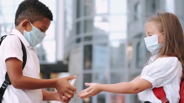 Crianças em idade escolar desinfectando as mãos durante a pandemia de coronavírus — Vídeo de Stock