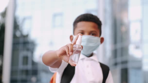 Afrykański amerykański chłopiec maska pokazując antyseptyczne stojąc na zewnątrz — Wideo stockowe