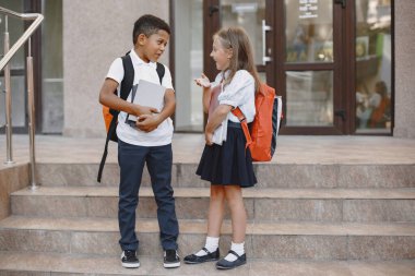 Küçük Afrikalı çocuk beyaz kızla ders çalışıyor.