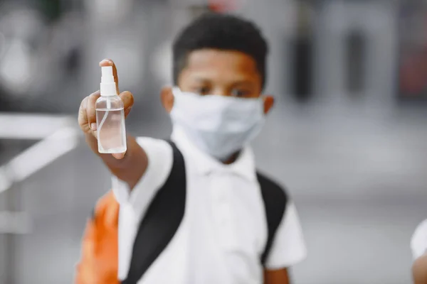 Pequeño niño stamdimg en una máscara médica — Foto de Stock