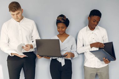 Uluslararası insanlar beyaz bir arkaplanda dizüstü bilgisayarla duruyorlar