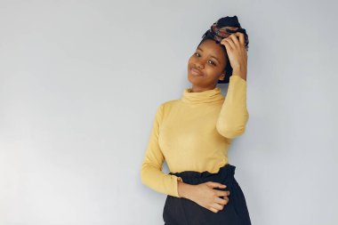 Beyaz arka planda duran sevimli siyahi kadın.