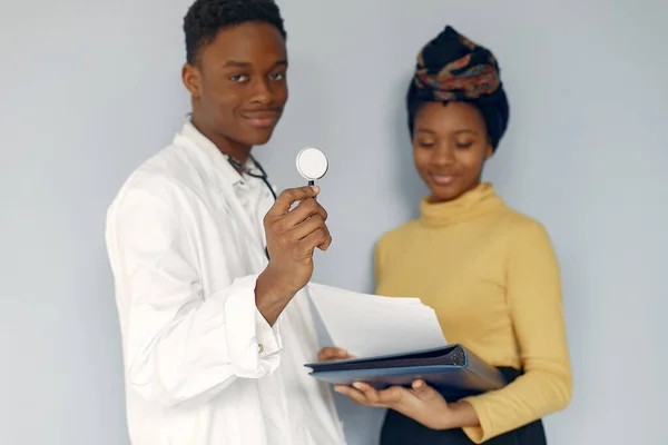 Black doctor in a white uniform with a stethoscope