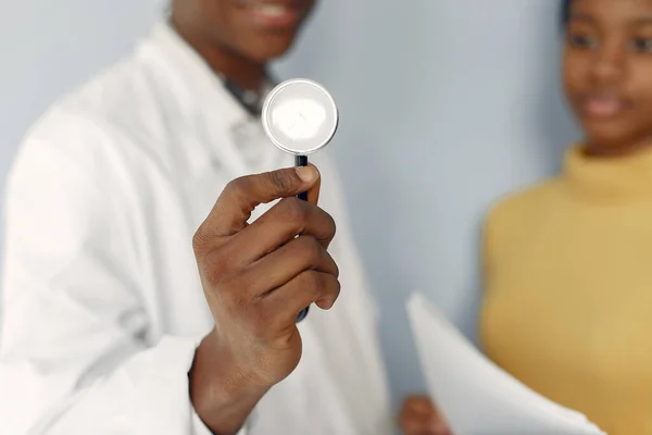 Black doctor in a white uniform with a stethoscope