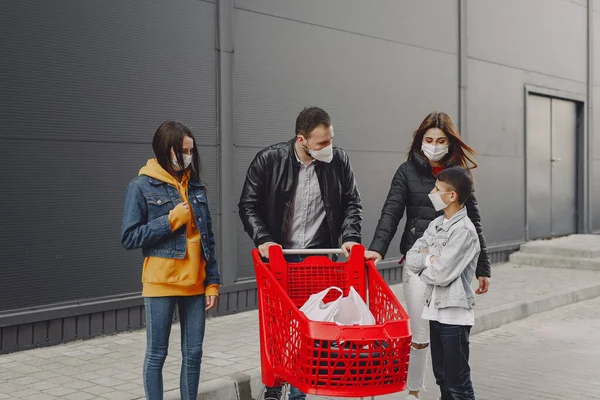 Familia en máscaras protectoras con compras —  Fotos de Stock